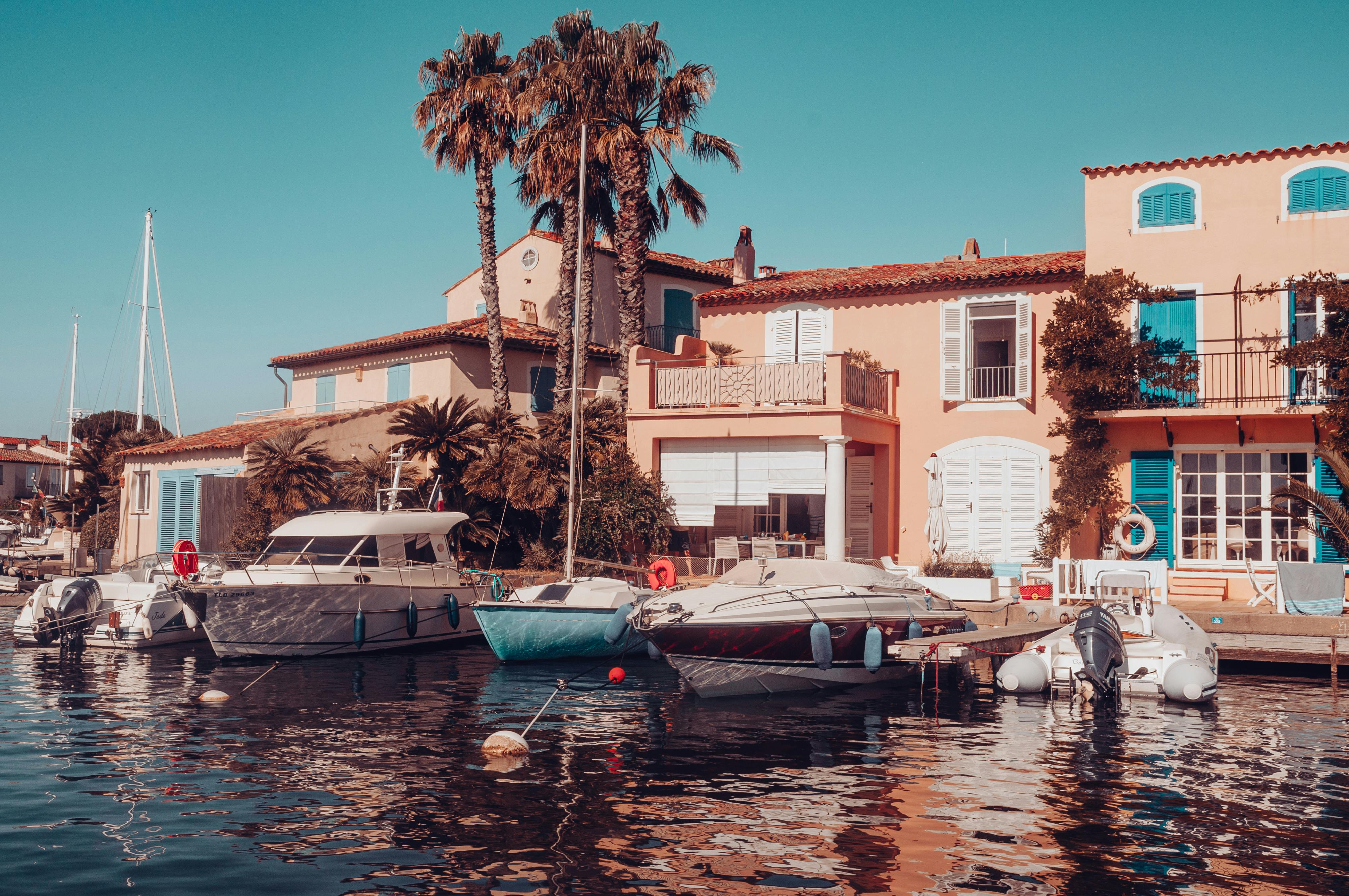 Scenic marina in Grimaud, France with yachts and Mediterranean architecture.