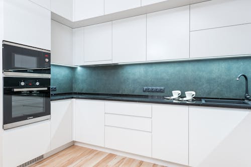 Free White minimalist kitchen with blue backsplash Stock Photo
