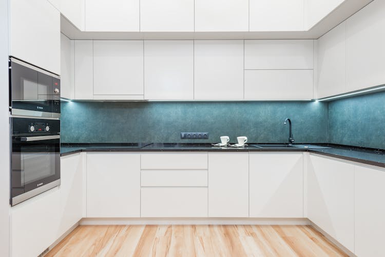 Kitchen Interior With White Cabinets And Black Appliances