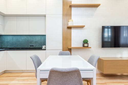 House with table with chairs next to kitchen and TV