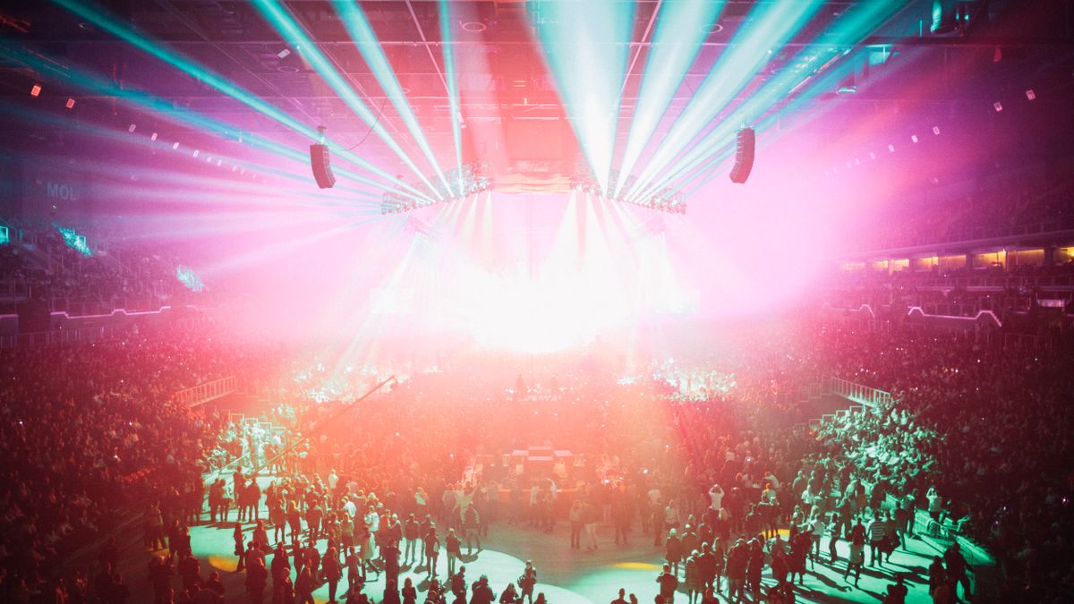 An electrifying concert scene with colorful lights and a large audience in Budapest Arena.