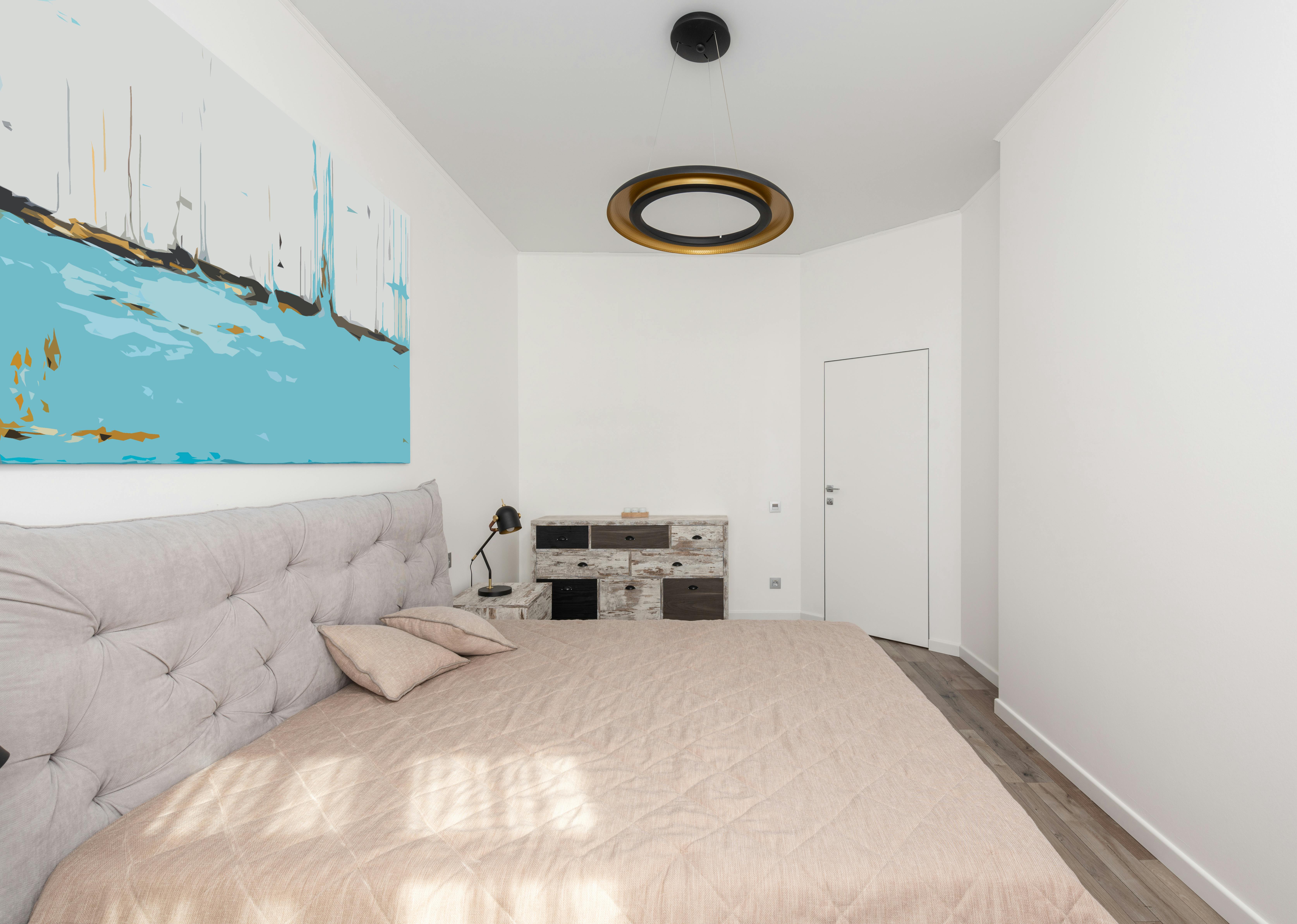 Bedroom interior with bed near table and painting on wall · Free Stock