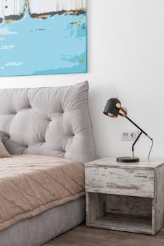 Contemporary bedroom featuring a bed, bedside lamp, and abstract painting on the wall.