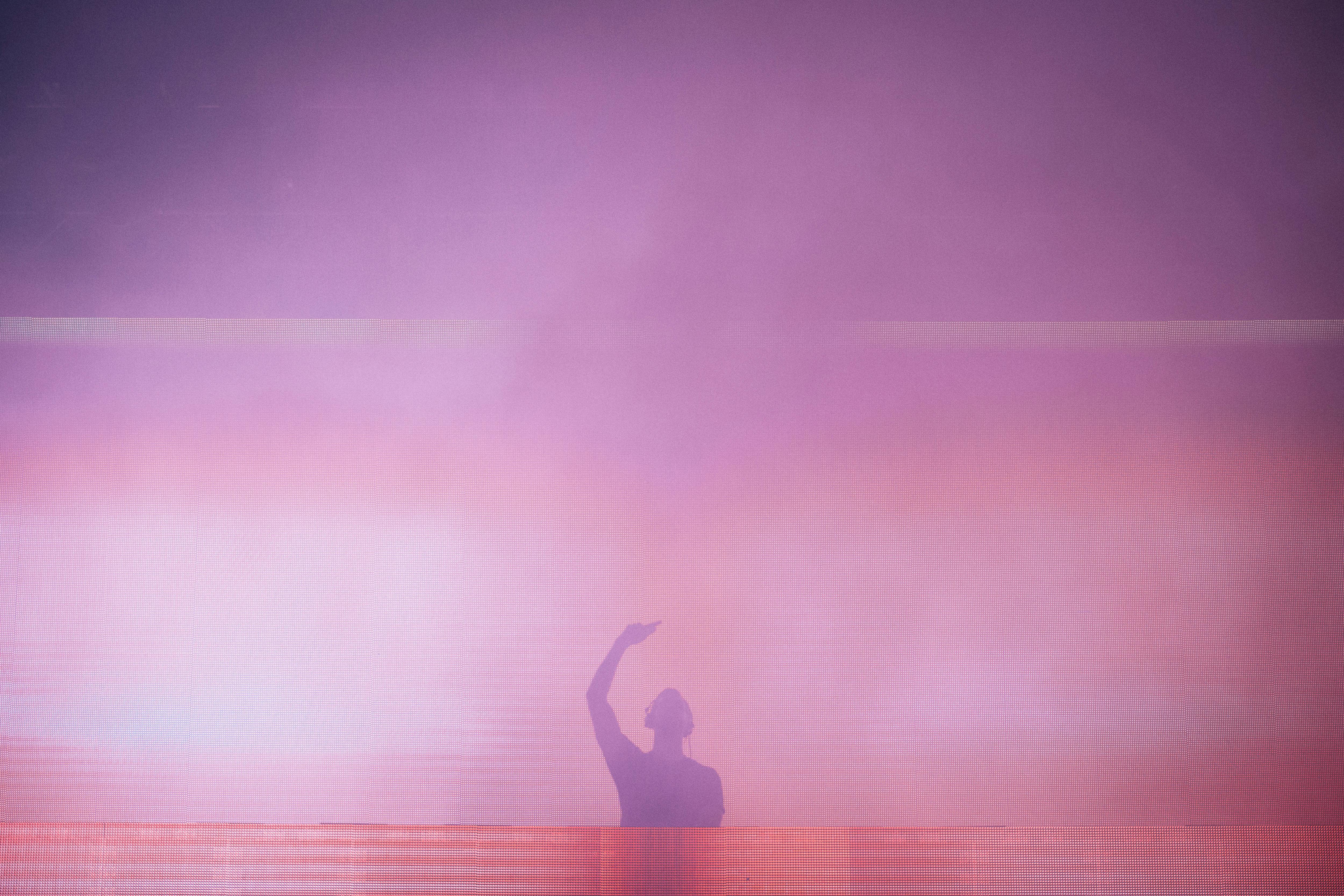 A DJ's silhouette set against colorful stage lights during a live performance in Zamárdi, Hungary.