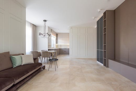 Bright and spacious modern apartment with minimalist decor featuring a chandelier and stylish furniture.