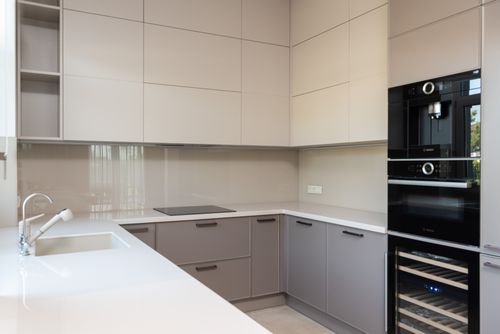 Free Interior of bright modern kitchen with cabinets with sink with faucet near stove and oven under microwave Stock Photo