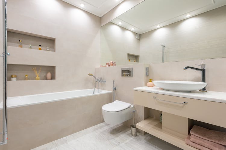 Bathroom Interior With Sink On Counter Near Toilet And Bath