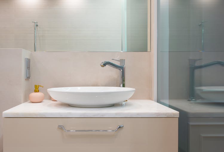 Restroom Interior With Sink And Tap On Counter Near Mirror