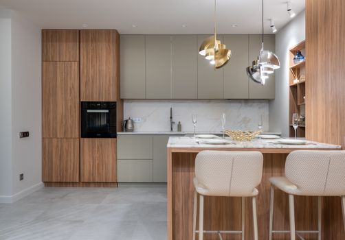 Kitchen interior with chairs and counter near cupboards