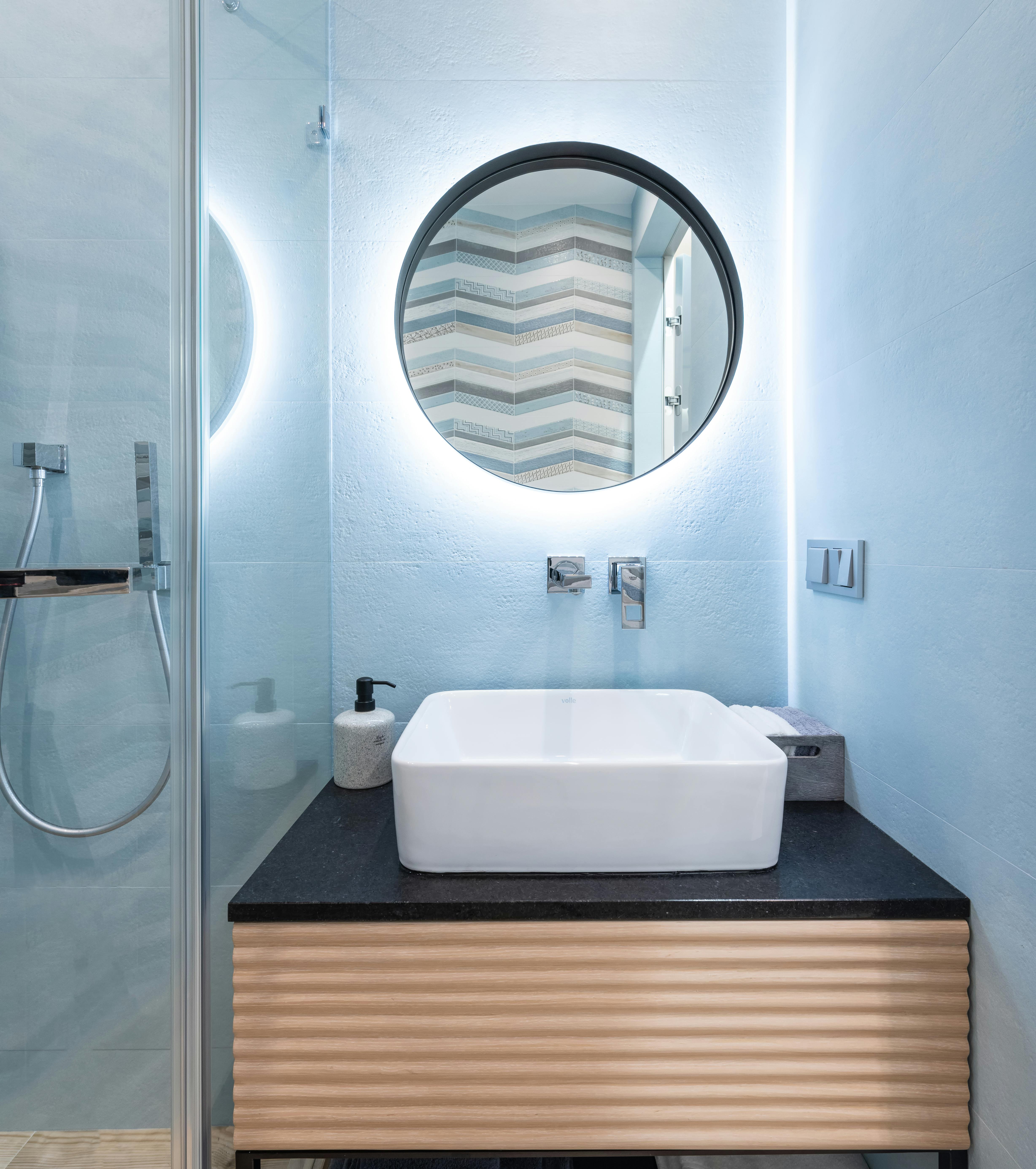 washroom interior with sink and faucet on cabinet near mirror