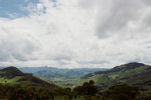 Free Picturesque landscape of vast hilly valley covered with abundant green plants under cloudy sky Stock Photo