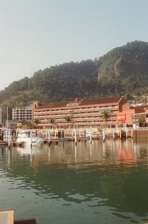 Hotel located on coast of lake against green hills