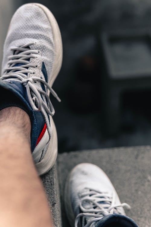 A Person Wearing Gray and Blue Rubber Shoes