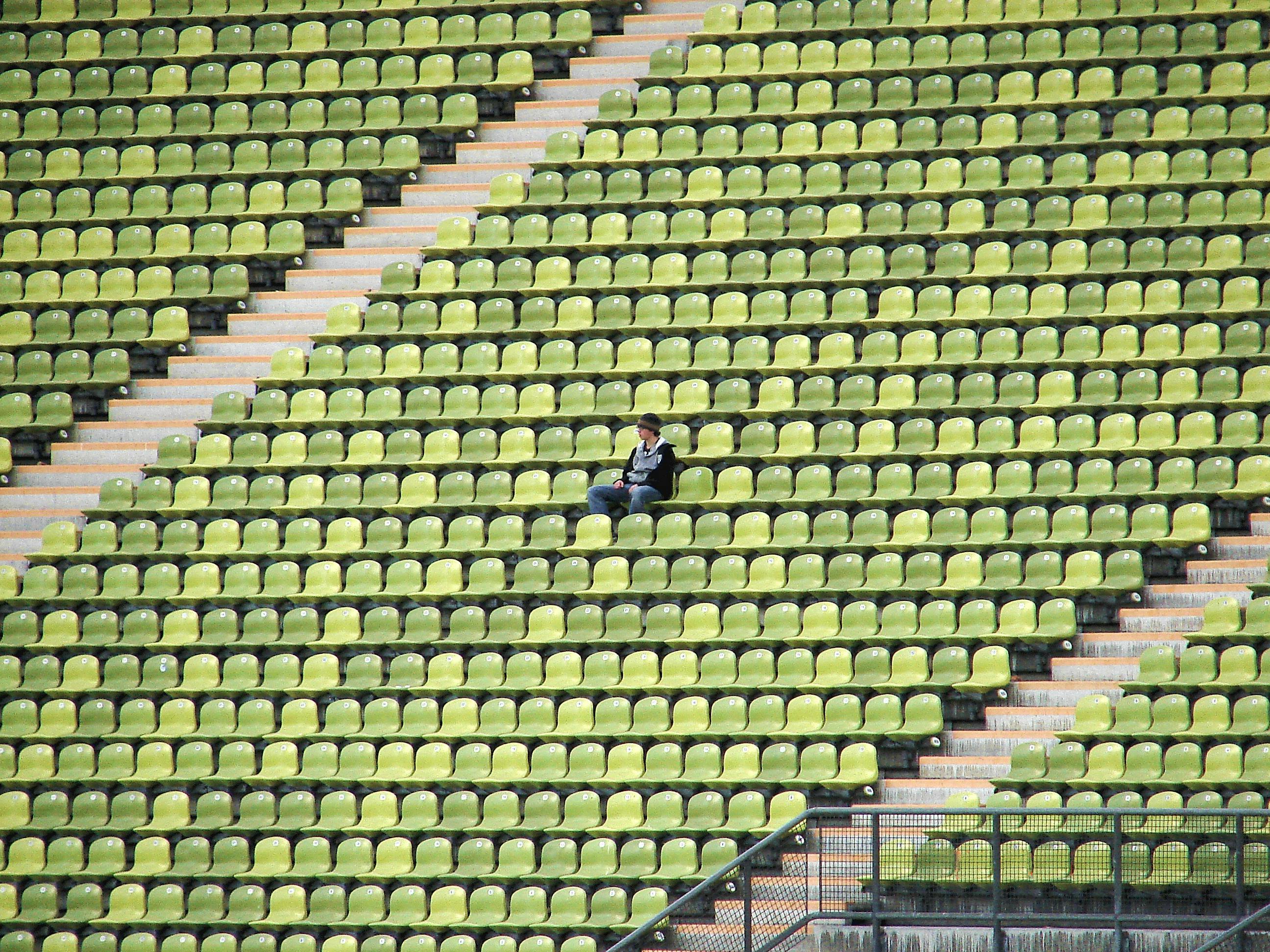 woman in grey shirt sitting on stadium chair