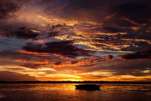 Free A silhouette of a boat during a dramatic sunset over the ocean in Bogo City, Visayas. Stock Photo