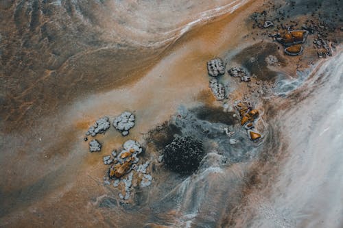 Rough stones scattered on ocean sandy beach