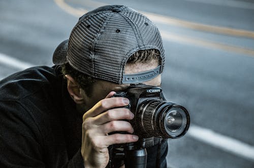 Man Taking Photo Using Black Canon DSLR Camera