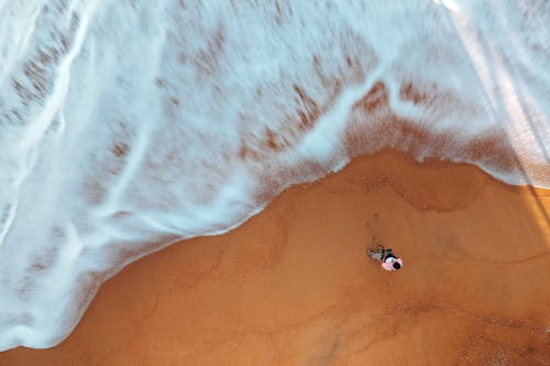 Unrecognizable man admiring seascape on sandy beach