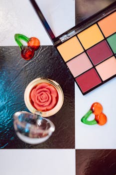 Flat lay of a makeup palette and rose-shaped blush on a black and white background.