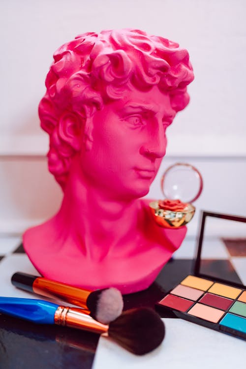 A Pink Head Bust Beside Makeup Brushes