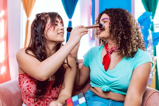 Two friends enjoying a playful makeup session, smiling in a colorful, vibrant setting.