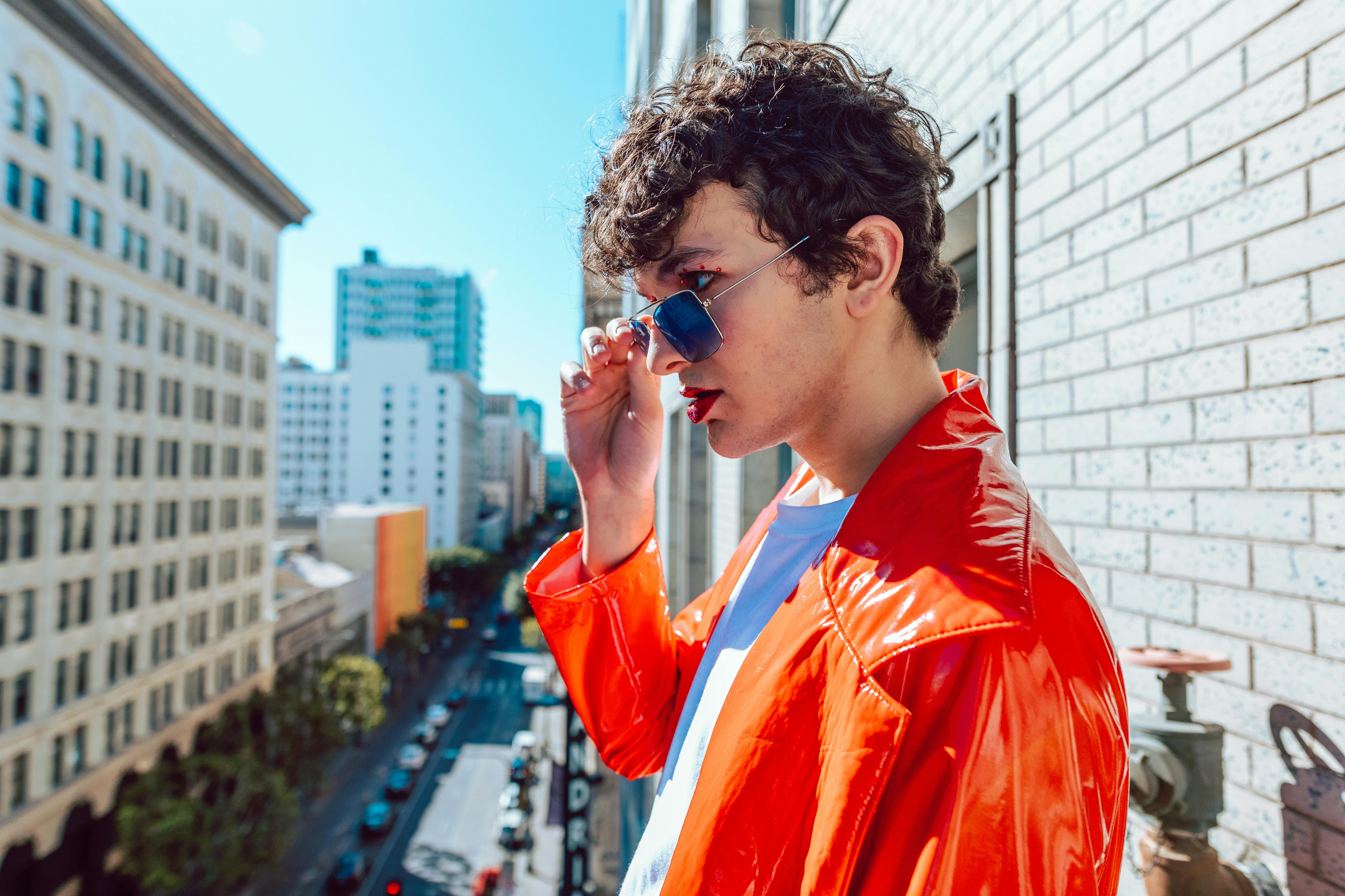 man wearing orange raincoat and a sunglasses