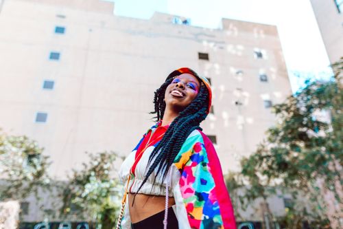 Free Young woman in colorful street fashion enjoying a sunny day outdoors. Stock Photo