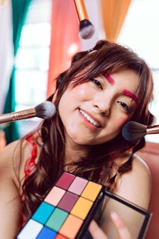 Close-up portrait of a young woman with vibrant makeup and colorful eyeshadow palette.