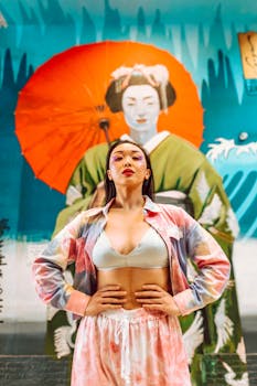 A woman poses stylishly in front of a vibrant geisha mural blending tradition and modernity.