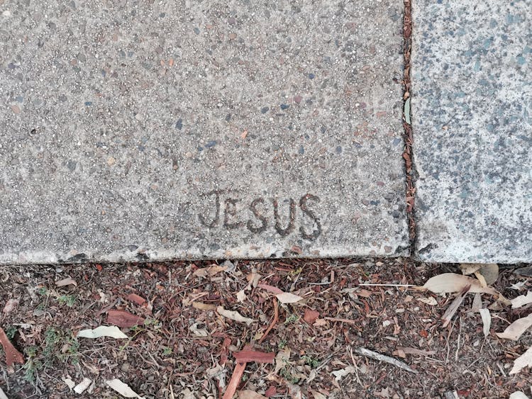 Jesus' Name Engraved On Concrete Surface