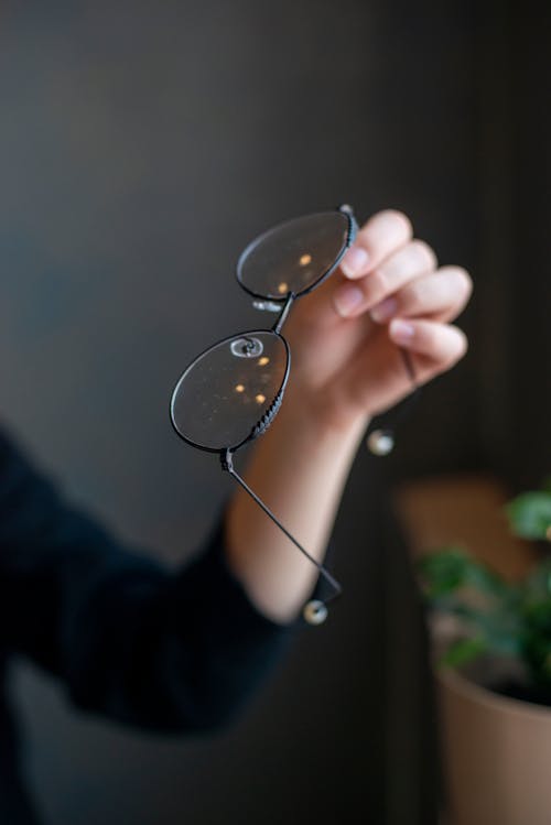 Free Photo of a Person's Hand Holding Black Framed Eyeglasses Stock Photo