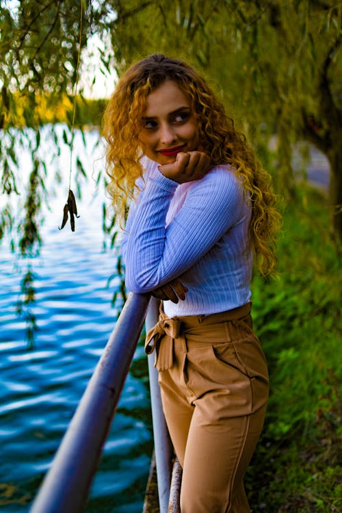 Woman with Blond Curly Hair Posing with Her Hand on Her Chin
