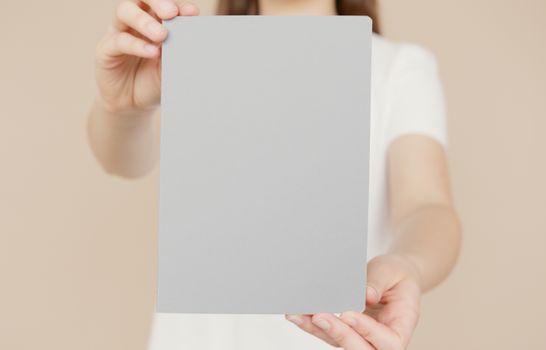 Person holding a blank card for mockup, ideal for design presentations or invitations.