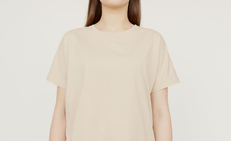 Sand coloured heavyweight tee worn against a neutral studio wall — photo by Artem Podrez on Pexels