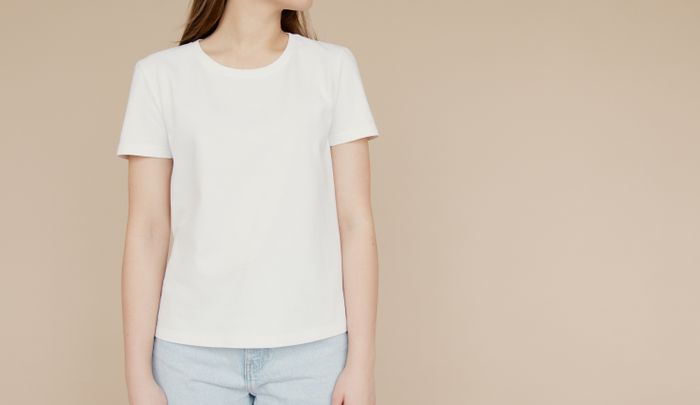 Model in a white tee on a beige background — photo by Artem Podrez on Pexels