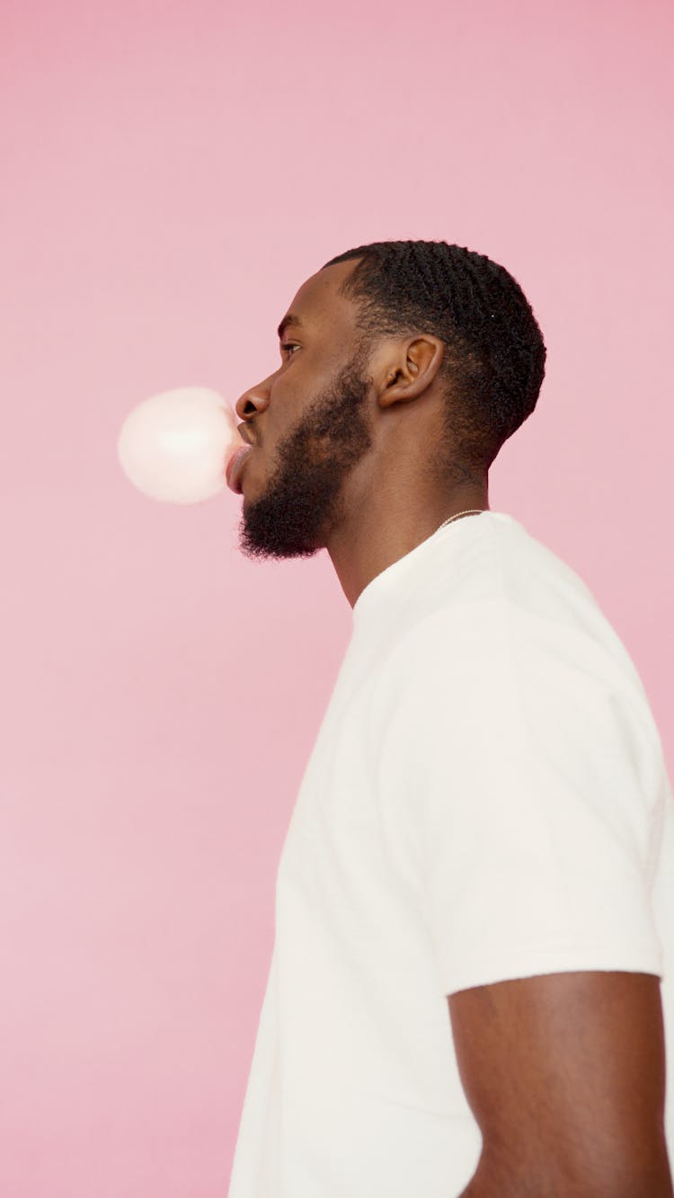 Bearded Man In A White Shirt Blowing A Bubble Gum