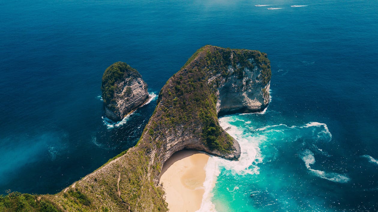 Green rocky cliff jutting into turquoise ocean