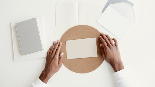 Person Holding A Round Cardboard With White Paper