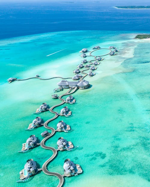 Gratuit Photographie Aérienne De L'île Avec Des Chalets Entourés D'eau Photos
