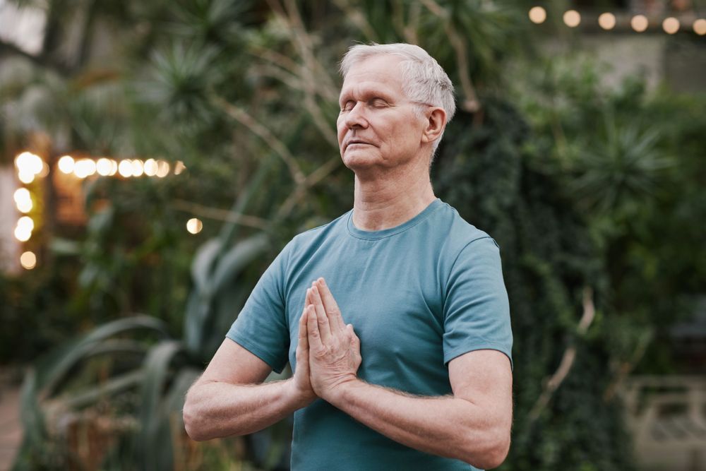 Older adult meditating outdoors