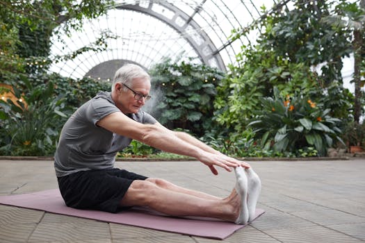 Senior man in peaceful yoga pose surrounded by lush greenery in a botanical garden.