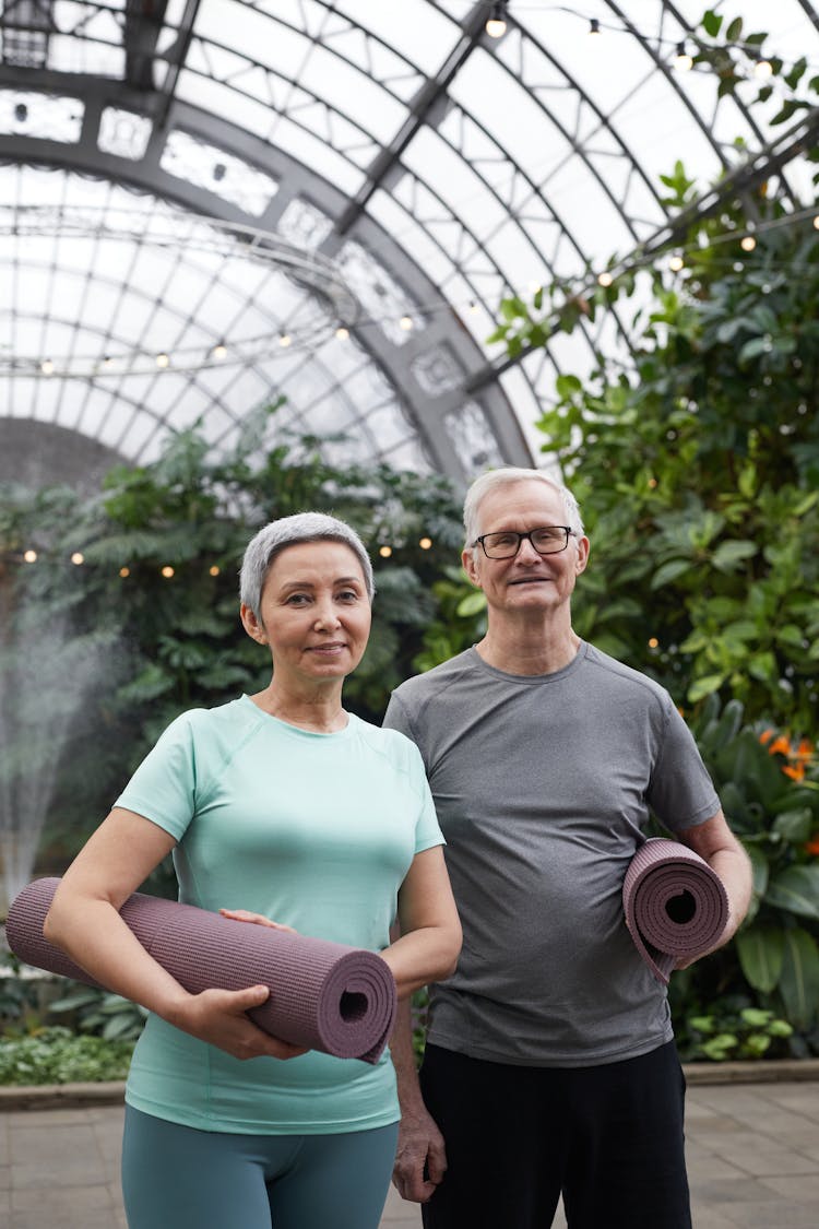 Couple Smiling While Holding Yoga Mats