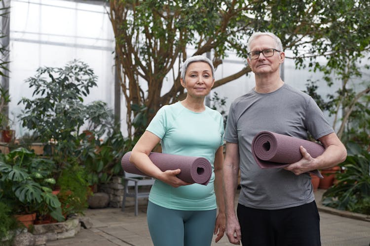 Couple Smiling While Holding Yoga Mats