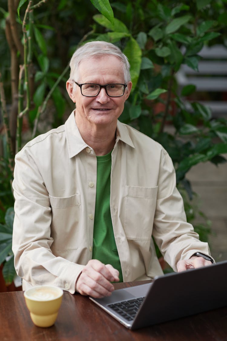 Man Smiling While Using His Laptop