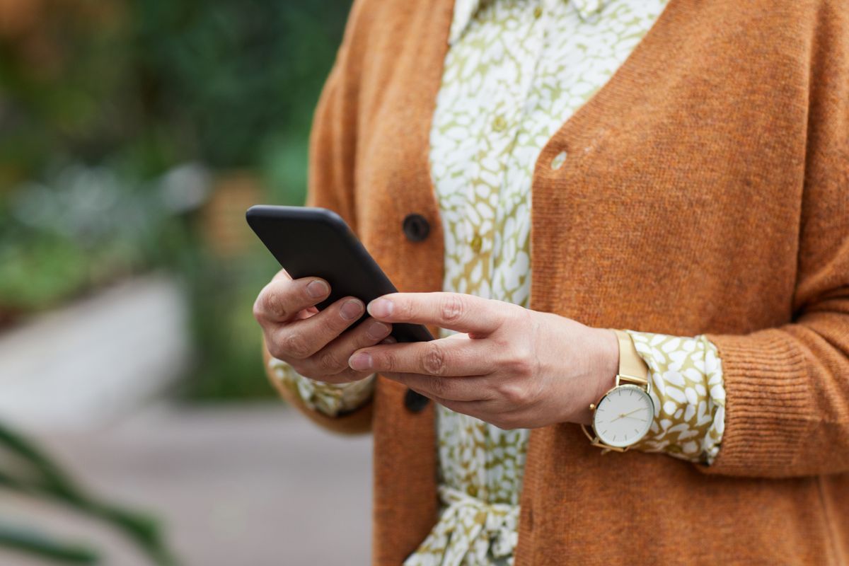 Akıllı telefon tutan eller, mobil oyun deneyimini sembolize eden rahat bir ortam