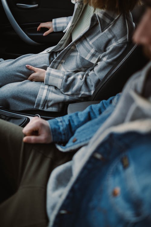 Man in Denim Jacket Sitting in the Car with a Woman Wearing Plaid Long Sleeves