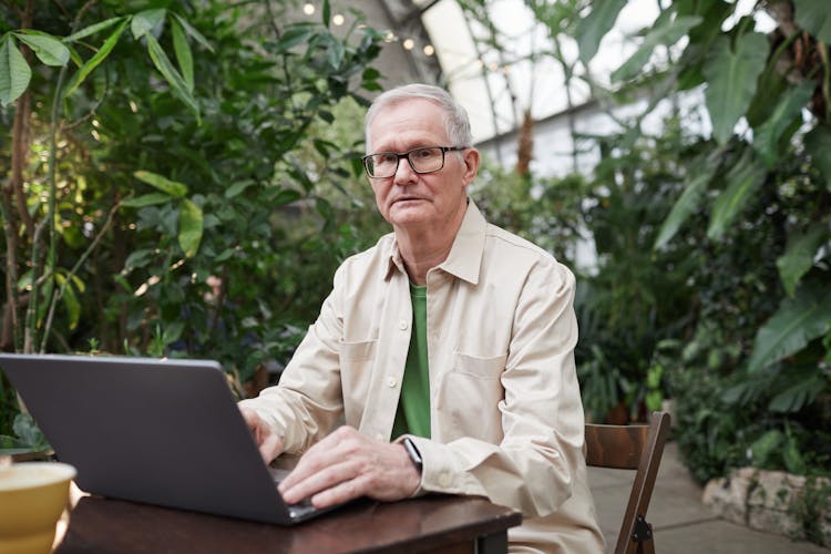 Man Using His Laptop While Looking At The Camera