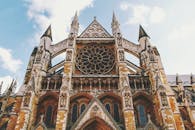 从低角度仰望伦敦威斯敏斯特大教堂的哥特式立面，天空明亮