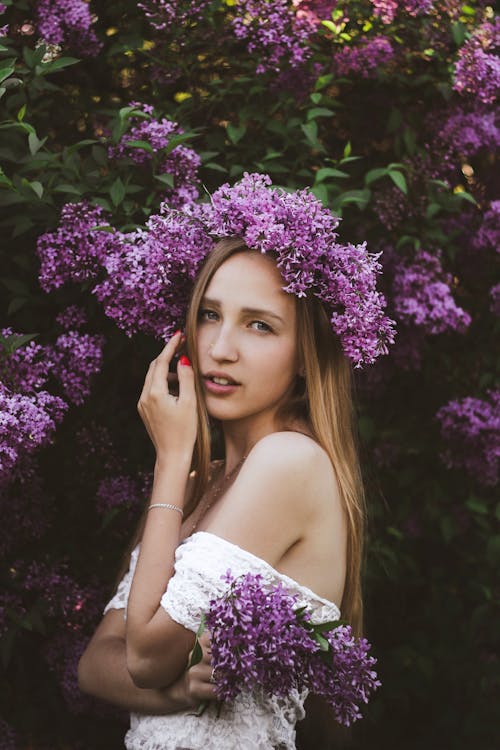 Young woman with lilac flowers in wreath