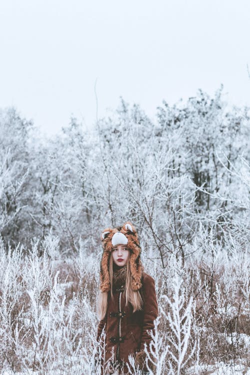 Woman in winter countryside in tiger cap